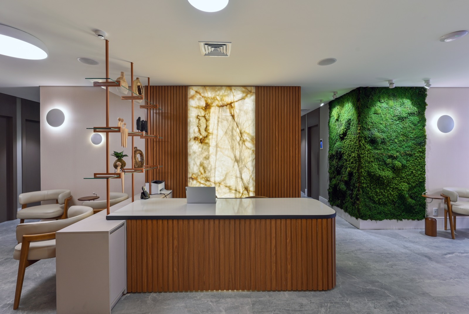 Recepção com balcão de madeira e painel de mármore iluminado